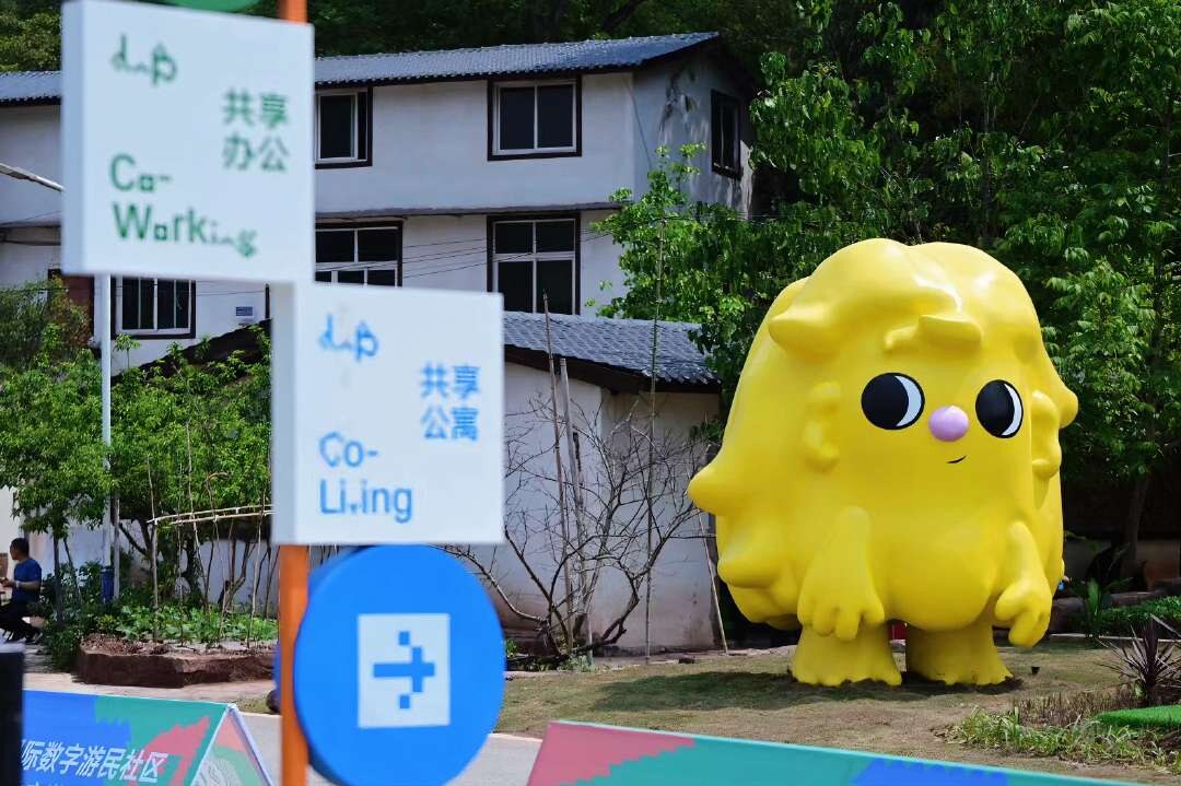 Large yellow character sculpture in a community setting